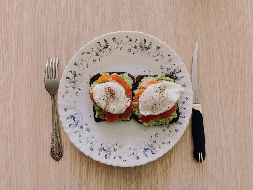 Overhead photo of a breakfast plate with eggs, avocado and toast, the kind of meal an AI calorie scanner estimates from a photograph