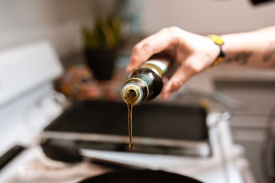 Olive oil being poured into a frying pan, the hidden cooking fat a calorie scanner cannot see in a photograph